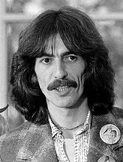 Harrison with shoulder-length hair and a moustache
