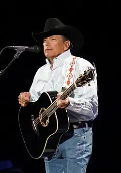A photo of George Strait playing a guitar