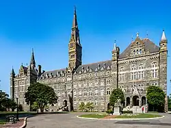 A large Gothic-style stone building dominated by a tall clocktower.