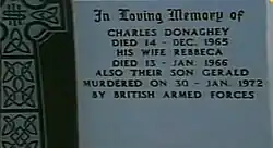 "Light blue headstone with Celtic cross to the left and wording: 'In loving memory of Charles Donaghey died 14 - Dec. 1965; his wife Rebecca died 13 - Jan. 1966; also their son Gerald murdered on 30 Jan. - 1972 by British armed forces'"