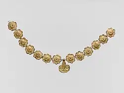 Mycenaean necklace; 1400–1050 BC; gilded terracotta; diameter of the rosettes: 2.7 centimetres (1.1&nbsp;in), with variations of circa 0.1 centimetres (0.039&nbsp;in), length of the pendant 3.7 centimetres (1.5&nbsp;in); Metropolitan Museum of Art (New York City)
