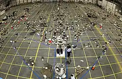 Large area with tape outline of orbiter and debris on the floor.