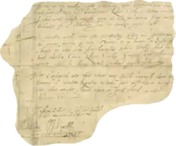 A small irregular section of parchment upon which several lines of handwritten text are visible. Several elaborate signatures bookend the text, at the bottom.