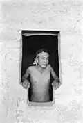Emmett Harryson, a Navajo, at a T-shaped doorway at Balcony House (1929)