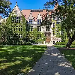 A path in the grass leading towards a large, partially ivy-covered building