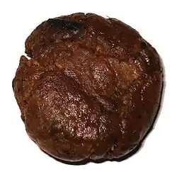 Ball of resin with a waxy appearance and dark reddish-brown color.
