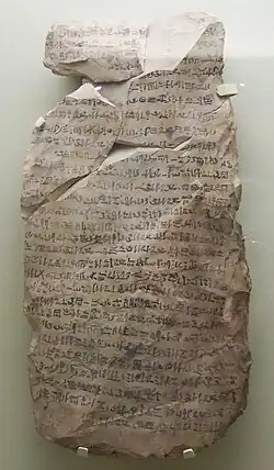 A stone fragment with cursive hieratic handwriting in black ink
