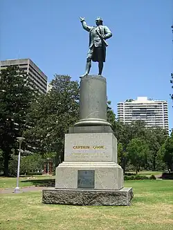A bronze statue of Cook, mounted atop a large granite base