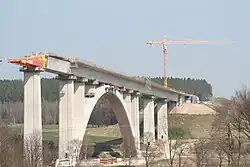 A large concrete arch bridge being constructed