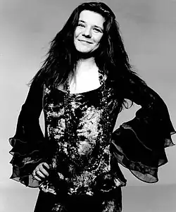 Portrait photo of Janis Joplin posing and smiling.