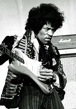 Hendrix playing on a guitar