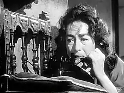Facial shot of a dishevelled middle-aged woman on the telephone.