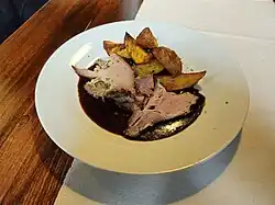 Juicy sliced pork neck marinated in Jack Daniel's sauce, served with roasted potatoes
