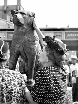 Woman touching a dog statue
