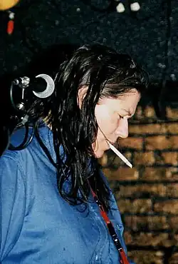 Kim Deal smoking in a dark venue