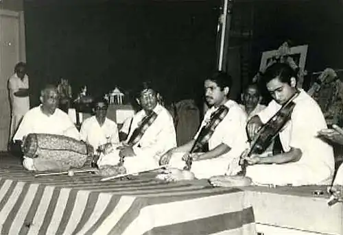 Carnatic music mridangam player Palghat Mani Iyer (left) at a concert with three violinists, from left to right: L. Vaidyanathan, L. Subramaniam, and L. Shankar.