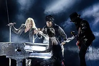 Mötley Crüe performing at Sweden Rock Festival in 2012, from left to right: Vince Neil, Nikki Sixx (background), Tommy Lee (foreground), Mick Mars