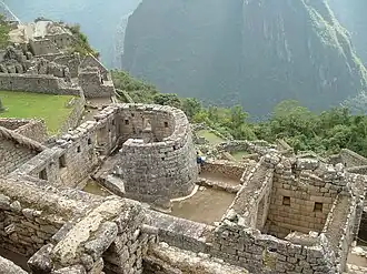 Temple of the Sun with stone structures and a backdrop of mountains.