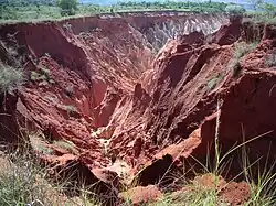 A vast, red soil gully caused by erosion