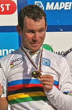A man on a podium holding a medal around his neck