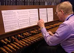 A man plays the Victorian Christmas carol "Good King Wenceslas" on a carillon's wooden keyboard with his fists, during this carillon's annual Christmas recitals during the 2016 holiday season.