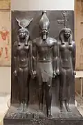 Statue of Menkaure with Hathor and Cynopolis; 2551–2523&nbsp;BC; schist; height: 95.5&nbsp;cm; Egyptian Museum (Cairo). Demonstrates a group statue with Old Kingdom features and proportions.[36]