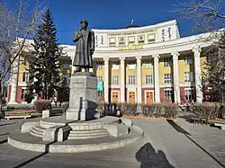 Statue in front of a large white building