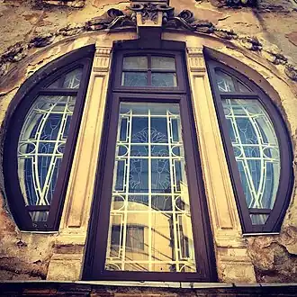 Mix of Art Nouveau and Egyptian Revival – Round corner window of the Romulus Porescu House (Strada Doctor Paleologu no. 12) in Bucharest, decorated with lotus flowers, a motif used frequently in Ancient Egyptian art, designed by Dimitrie Maimarolu (1905)[177]