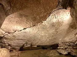 Spiral and lozenge art on stone in passageway