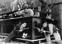 Keaton (left) with Roscoe Arbuckle (top) and Al St. John in a still from Out West (1918)
