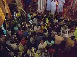 Orthodox congregation in India collects palm fronds for procession: men on left of sanctuary in the photo; women collecting fronds on right of sanctuary, outside photo.