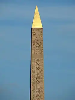 Hieroglyphs on the upper obelisk. The Pharaoh on his throne is portrayed at the top