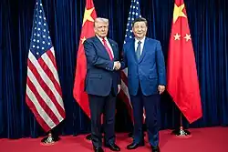 Donald Trump and Xi Jinping stand next to each other, both wearing suits