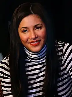 Close-up image of Velasquez in a striped turtleneck long-sleeve top