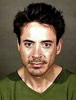 Mugshot of Downey, wearing a green shirt, looking directly at the camera with a slight smile