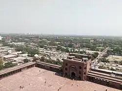 Image shows Red Fort's long walls, including the gates, as seen from Jama Masjid's tower. The walls can be seen in the background extending a couple of thousand meters.