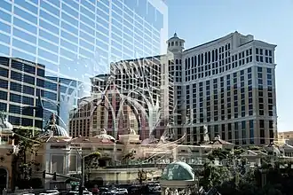 Reflection of Flamingo Las Vegas on a glass overpass in front of the Bellagio and Cosmopolitan