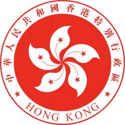 A red circular emblem, with a white 5-petalled flower design in the centre, and surrounded by the words "Hong Kong" and "中華人民共和國香港特別行政區"