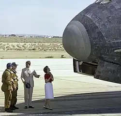 "President Ronald Reagan chats with NASA astronauts Henry Hartsfield and Ken Mattingly on the runway as first lady Nancy Reagan inspects the nose of Space Shuttle Columbia following its Independence Day landing at Edwards Air Force Base on July 4, 1982."[10]