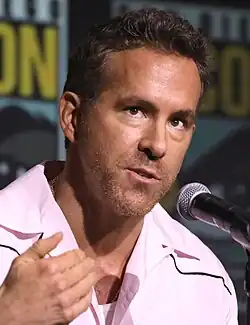 Reynolds speaking into a microphone