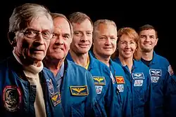 Photograph of Young and Crippen standing in a row with the crew of STS-135