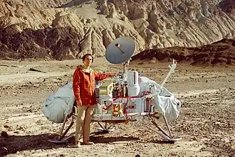 Carl Sagan standing beside a Viking Lander