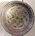 The Samarra bowl, from Iraq, circa 4,000 BCE, held at the Pergamonmuseum, Berlin. The swastika in the centre of the design is a reconstruction.[89]