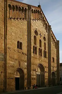 San Michele Maggiore, Pavia, The façade has the form of a screen, higher than the central nave, with a blind arcade below its roofline. It is divided into three bays by compound piers, has a variety of window openings, and horizontal bands of sculptural decoration.