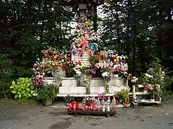 A statue, covered with flowers.