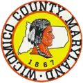 A round seal featuring a Native American and the county outline on a yellow background with a white-and-red border
