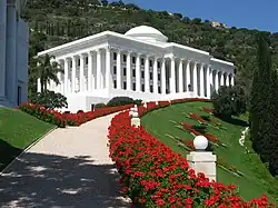 A white building with several columns and a domed roof.