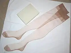 A pair of sheer ladies' stockings laying upon a white table