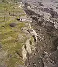 A house on the edge of a newly formed cliff.