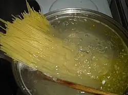 Spaghetti being placed in boiling water